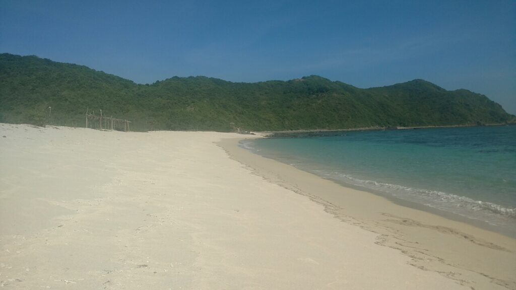 A sandy beach and turquoise sea on Lombok, Indonesia